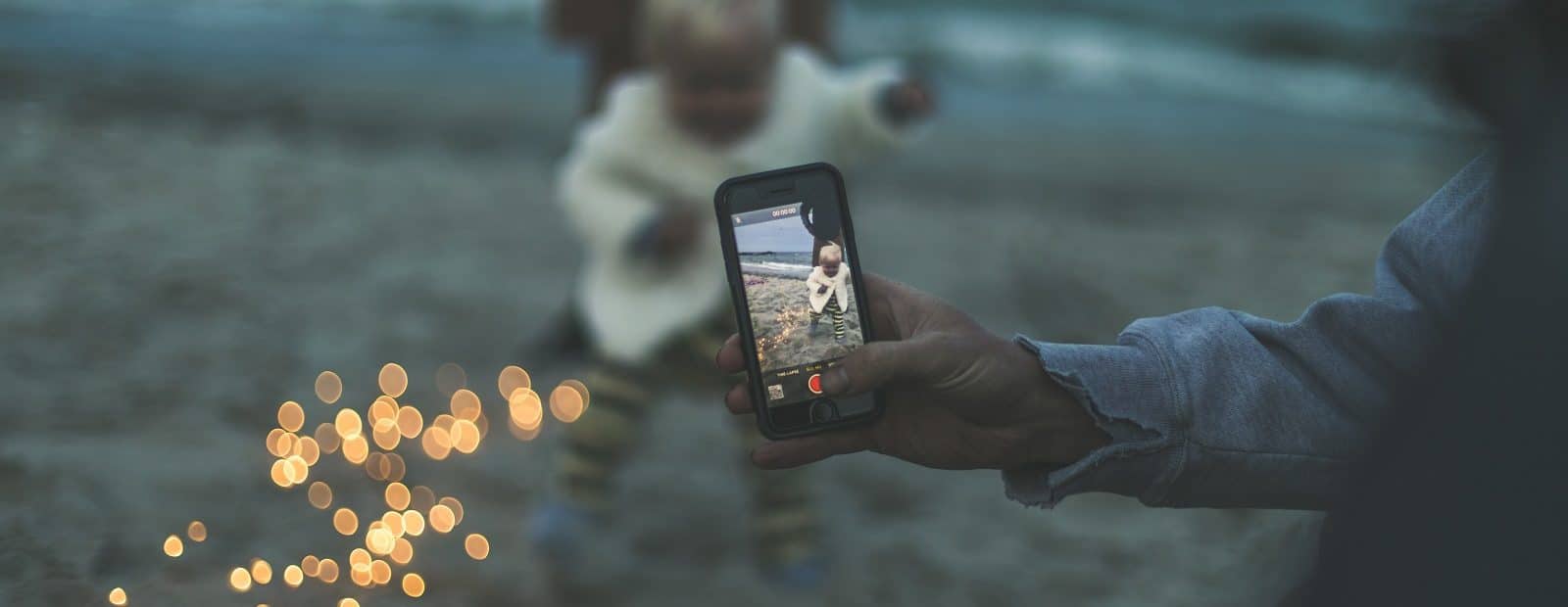 lasta valokuvataan hämärässä rannalla