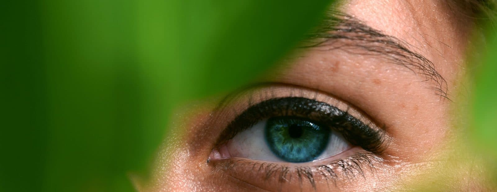 tyttö kurkistaa lehtien takaa