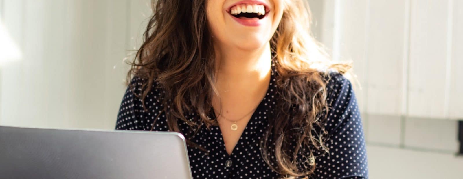 naurava nainen ja läppäri